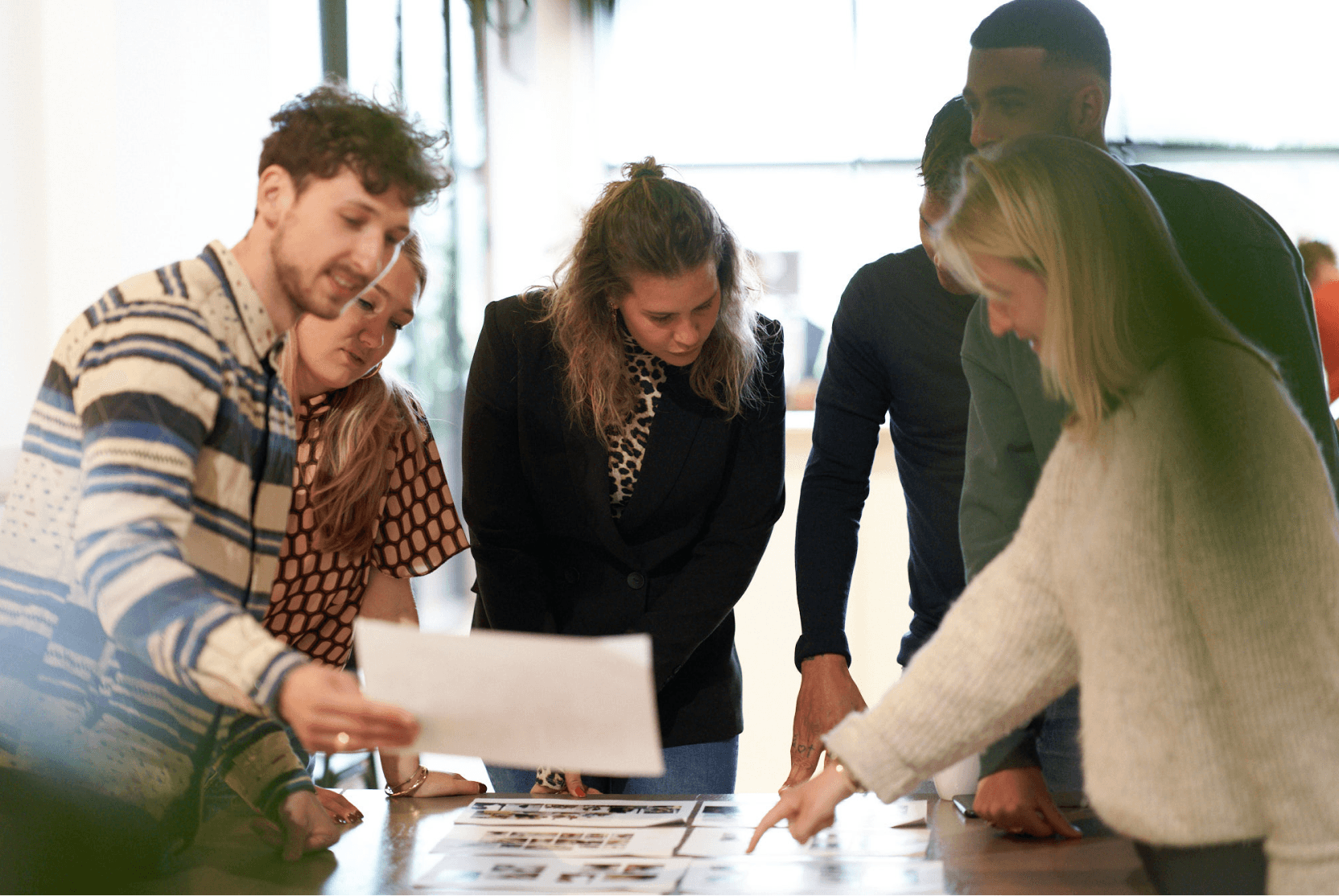 People brainstorming at a table with papers