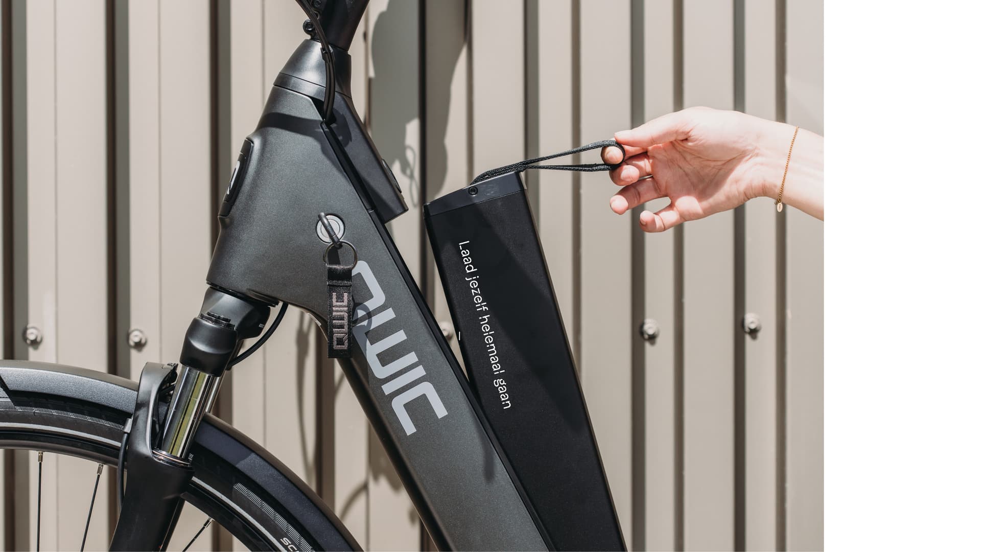 Hand takes out battery from e-bike
