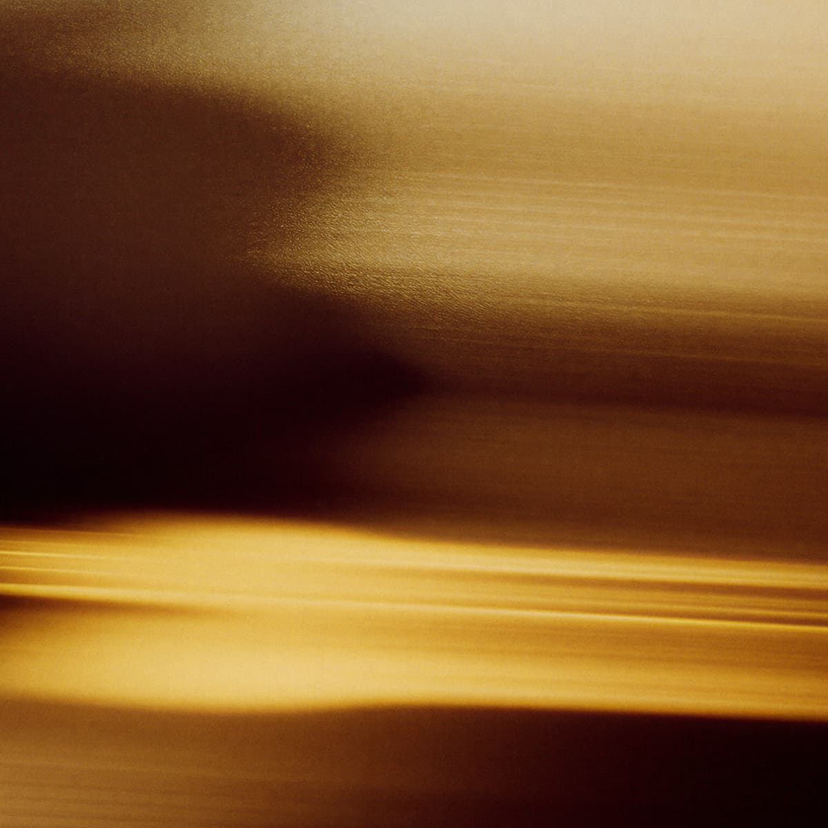 A blurred abstract background with warm, golden-brown tones and subtle horizontal streaks, creating a soft, flowing effect.