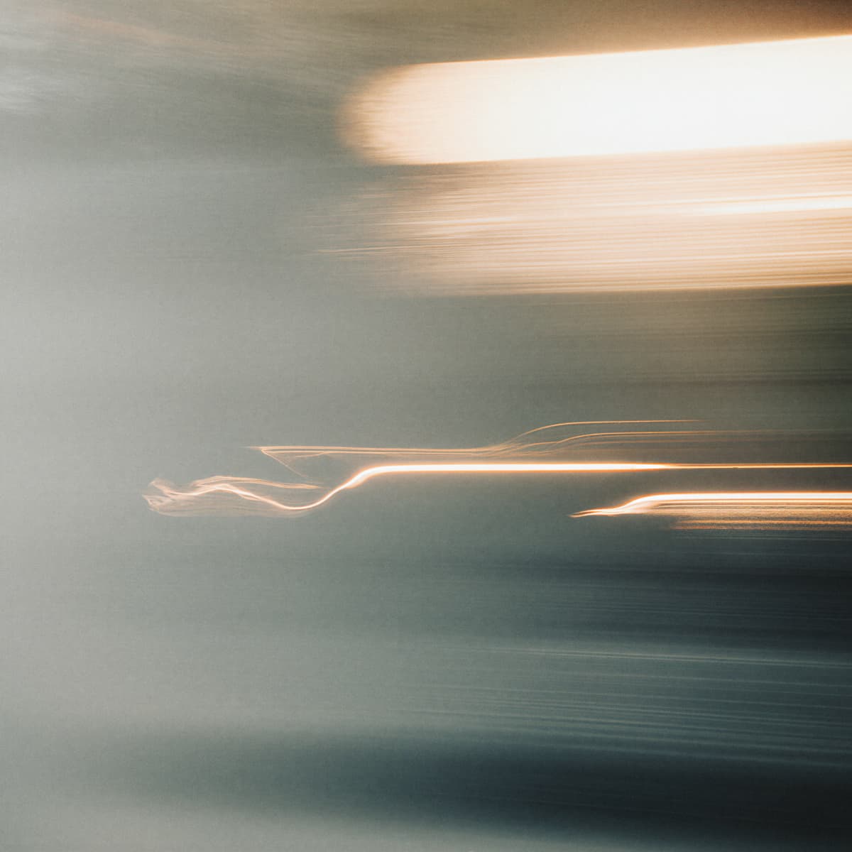 Abstract image of blurred motion with streaks of light across a dark background, creating a dynamic and ethereal effect.