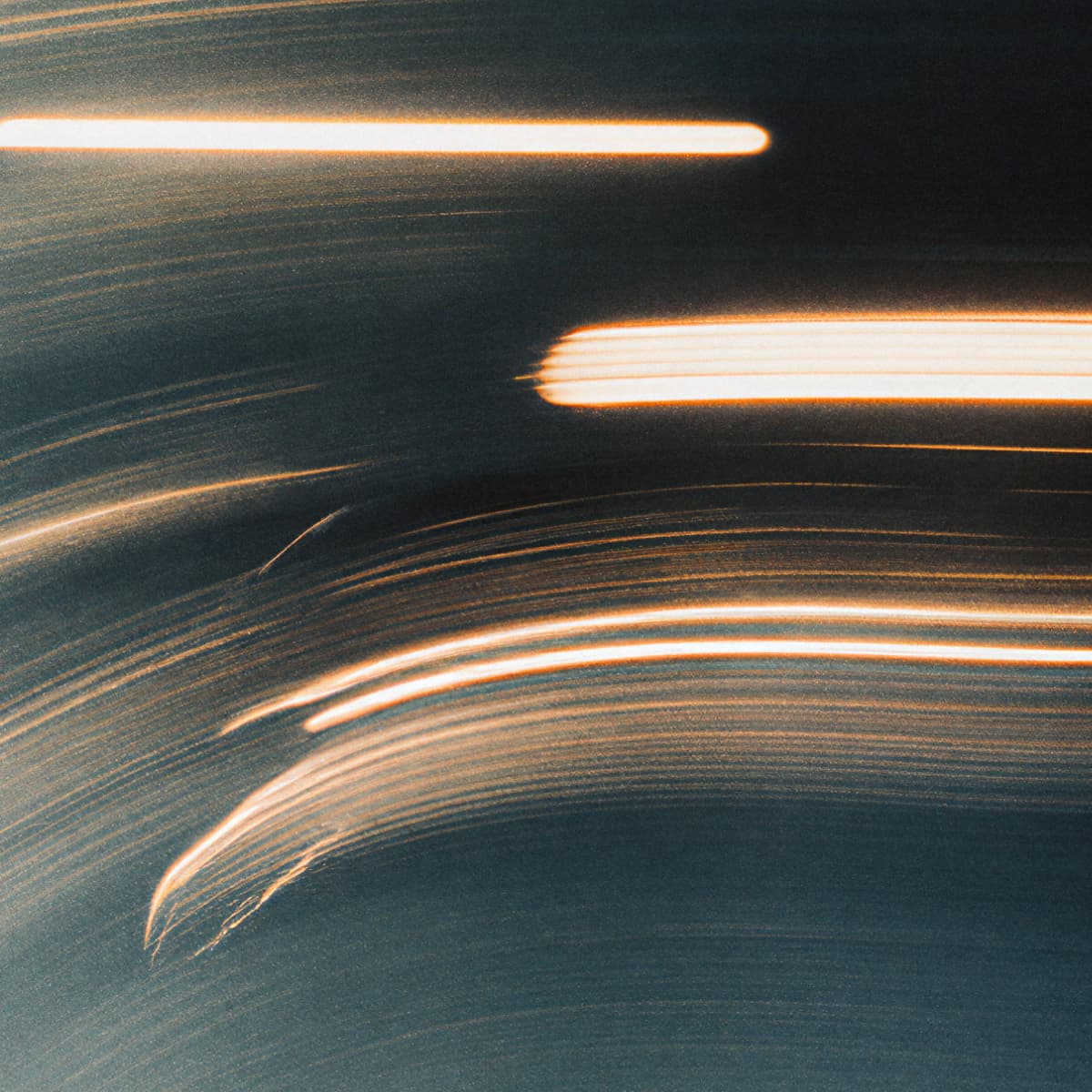 Abstract image featuring streaks of light in curved patterns against a dark background, creating a dynamic sense of motion.