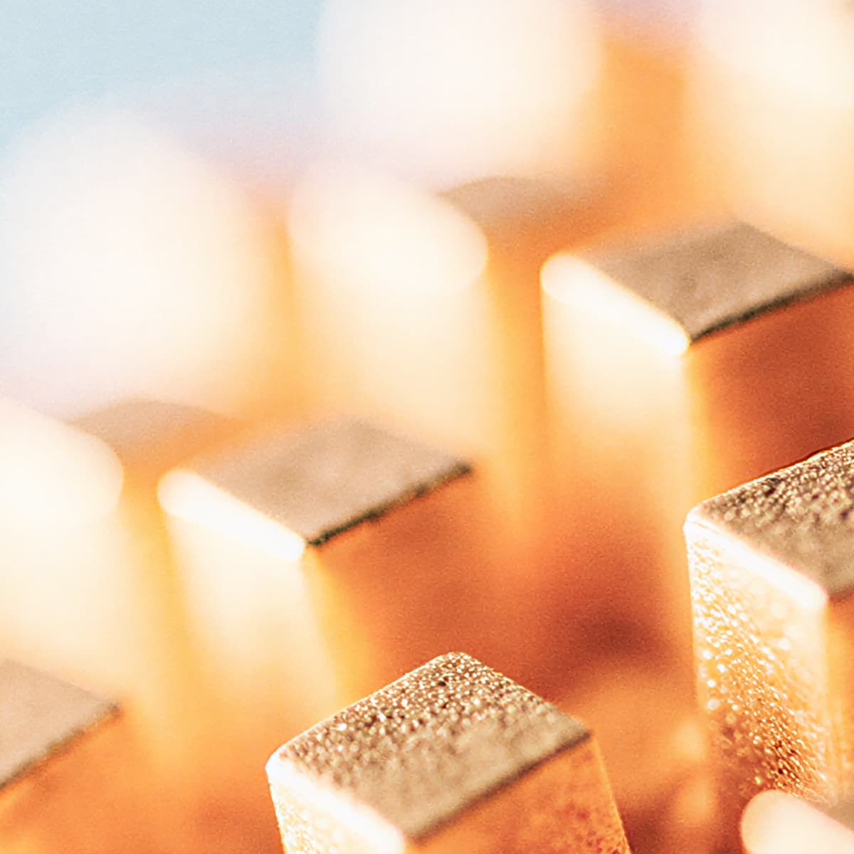 Close-up of a gold-colored heat sink on a computer processor, showing metallic fins with a soft focus background.