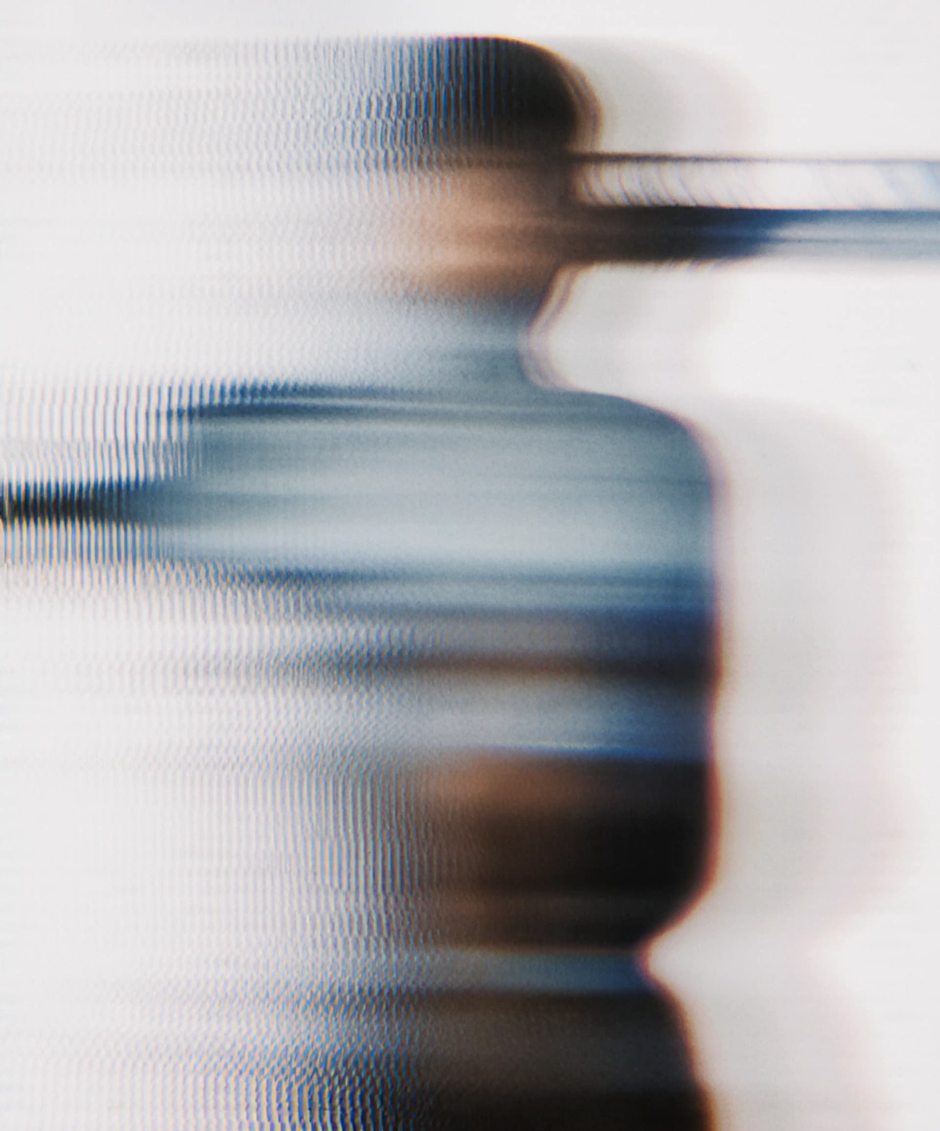 Abstract image with blurred, distorted horizontal lines and shapes, creating a sense of motion and obscurity in shades of blue and brown.