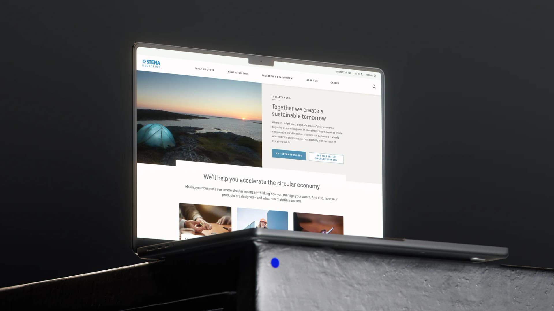 A sleek laptop displaying a website about creating a sustainable tomorrow, with a sunset image and text on circular economy strategies.